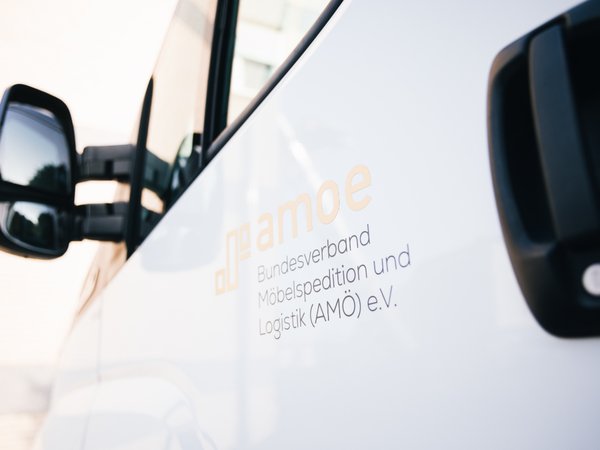 Bildmarke AMÖ auf Fahrzeugtür in Stimmung mit Sonnenlicht